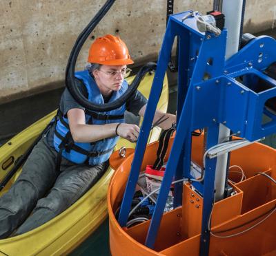 Graduate student Courtney Beringer makes adjustments to LUPA, a prototype wave energy converter tested at the O.H. Hinsdale Wave Research Lab.