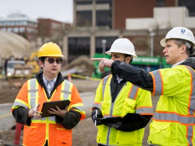 Faculty member John Gambatese at a construction filed site in hard hats.